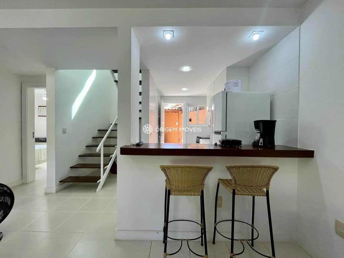 Vista cozinha americana, escada e quarto.